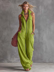 Bright green cotton linen jumpsuit with zip-front by FJØRNA, displayed on a hanger showing its relaxed fit and sleeveless design.