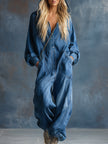 Blue denim hooded jumpsuit by FJØRNA featuring a button-front design and long sleeves, displayed on a hanger.