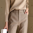 FJØRNA wool blend women's trousers, stylish pants with a tailored fit, shown in a neutral color on a model.