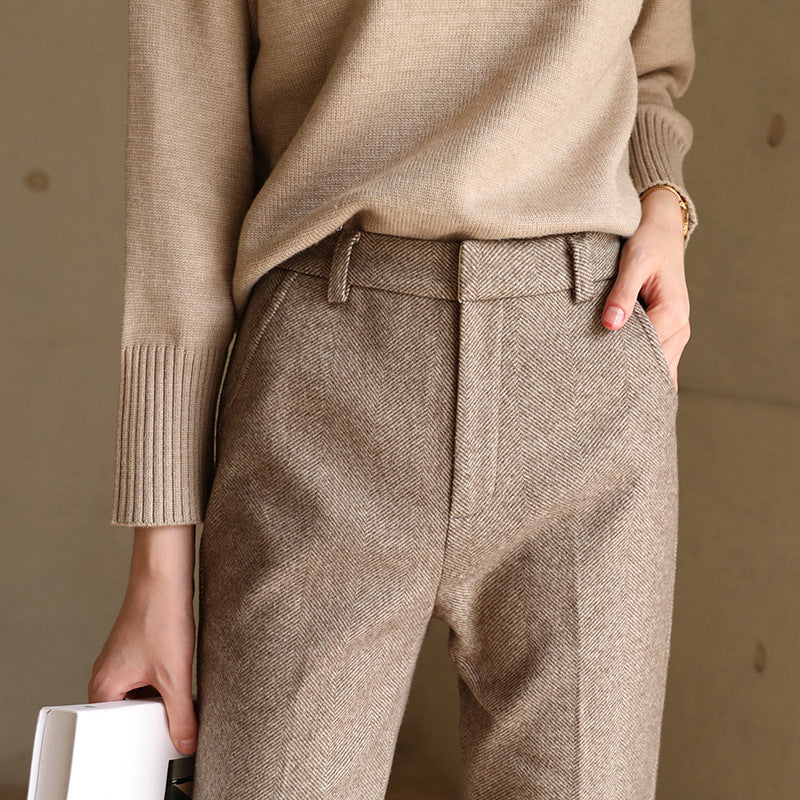 FJØRNA wool blend women's trousers, stylish pants with a tailored fit, shown in a neutral color on a model.