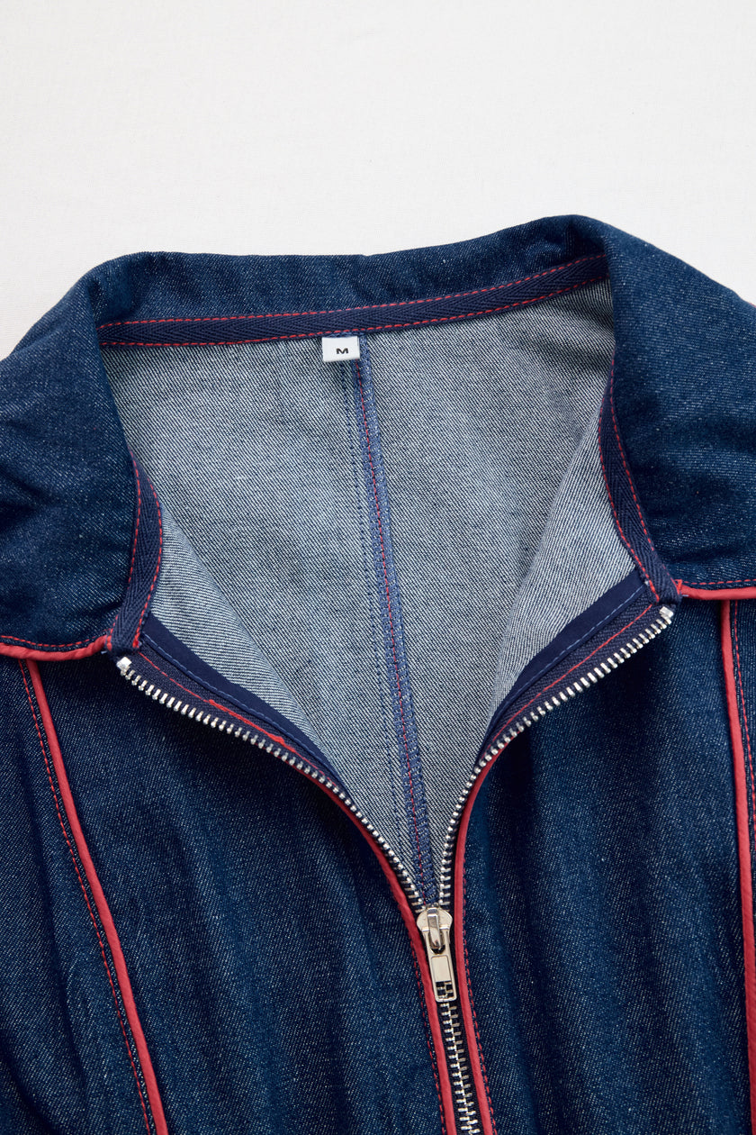 Dark blue FJØRNA denim jumpsuit with wide-leg design, topstitched details, and long sleeves.