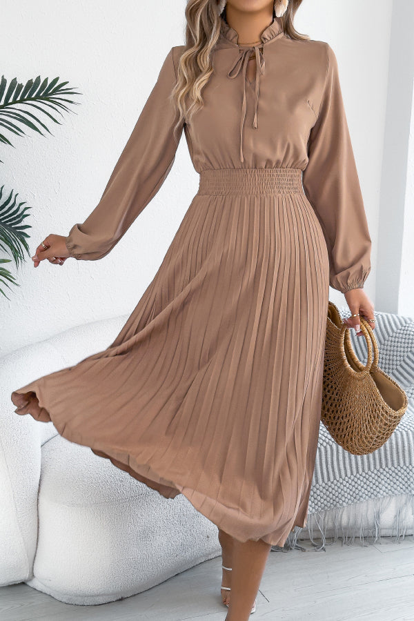 FJØRNA solid color long-sleeved fitted waist pleated midi dress displayed on a model, showcasing elegant design and tailored fit.