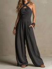 FJØRNA charcoal pinstripe halter neck wide-leg jumpsuit for women, featuring a stylish halter top and flowing wide-leg pants.