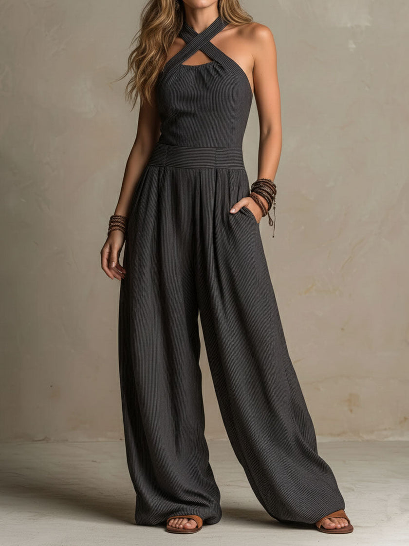 FJØRNA charcoal pinstripe halter neck wide-leg jumpsuit displayed on a mannequin, highlighting the halter neckline and flowing wide-leg design.