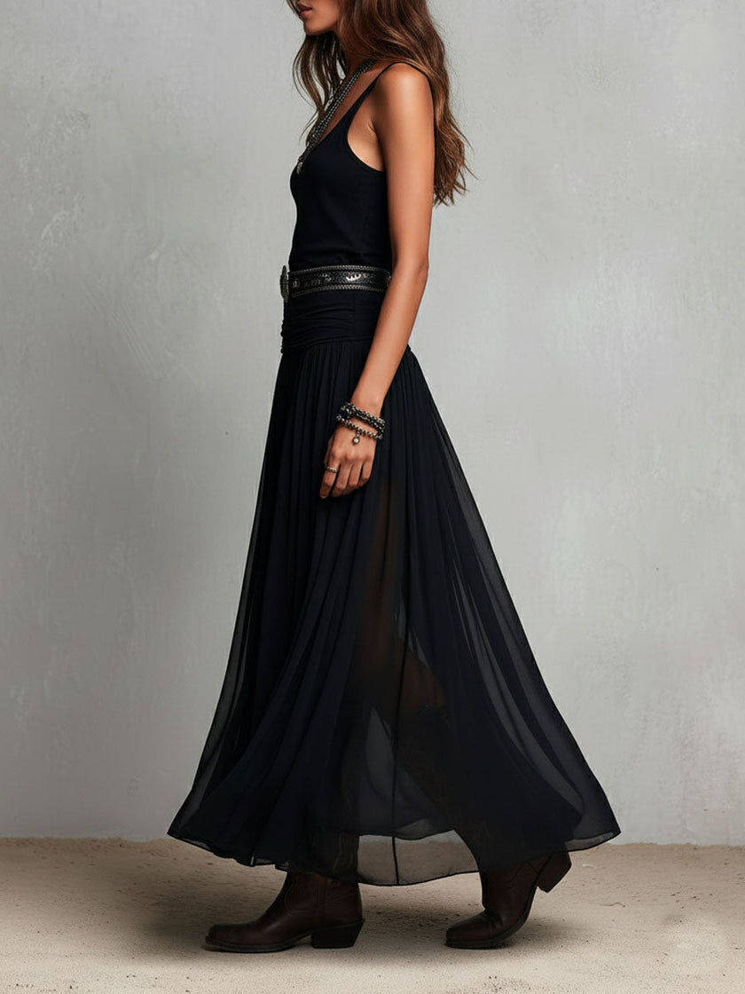 FJØRNA black maxi dress, casual style, flowing fabric, sleeveless design, full-length dress on a model.