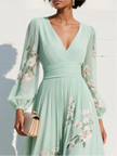 FJØRNA floral print long-sleeved V-neck pleated dress with elegant floral pattern and flowing fabric.