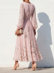 FJØRNA floral print long-sleeved V-neck pleated dress featuring an elegant design and vibrant floral pattern.