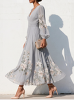 FJØRNA floral print long-sleeved V-neck pleated dress with elegant design and vibrant floral pattern, perfect for sophisticated occasions.