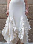 White FJØRNA ruffled hem midi gown with structured V-neck bodice and flowing skirt, perfect for elegant occasions.