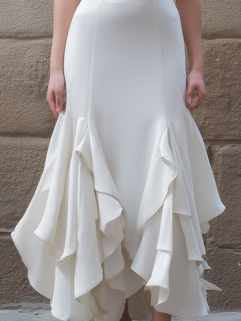 White FJØRNA ruffled hem midi gown with structured V-neck bodice and flowing skirt, perfect for elegant occasions.