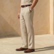Men's linen blend straight leg trousers by FJØRNA with pleats and relaxed fit, shown in a light, natural fabric finish.