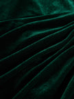 FJØRNA velvet midi evening dress showing a fitted waist and elegant flowy skirt on a model.