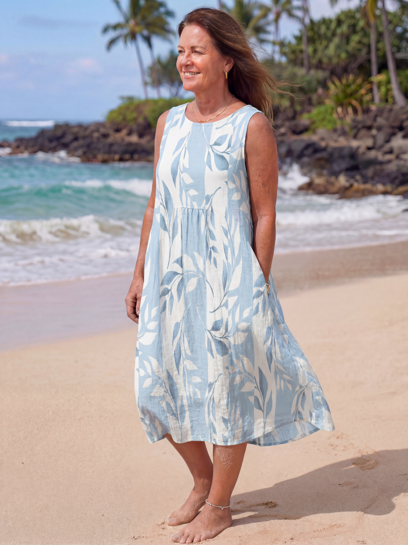 FJØRNA women's floral sleeveless summer midi dress hanging on a hanger, showcasing its lightweight fabric and vibrant print.