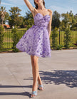 Black tulle cocktail dress for women with floral pattern and puff sleeves by FJØRNA, shown on a hanger.