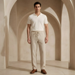 Men's linen trousers by FJØRNA with drawstring waist and relaxed fit, shown in natural light, highlighting breathable fabric and casual style.