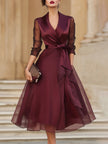 FJØRNA elegant wrap midi dress for women with sheer sleeves, featuring a flowing silhouette and sophisticated design.
