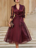 FJØRNA elegant wrap midi dress for women with sheer sleeves, featuring a flowing silhouette and sophisticated design.