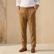 Men's linen blend straight leg trousers by FJØRNA with drawstring waist and relaxed fit, shown in a natural beige color.