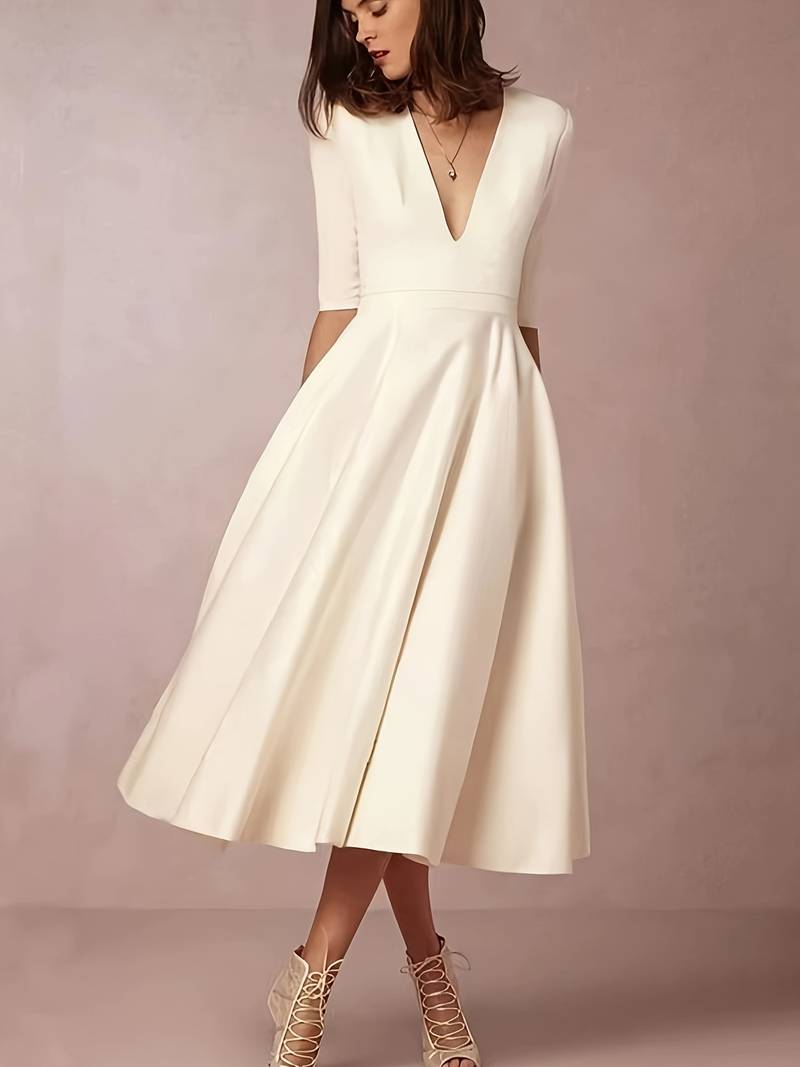Navy flared midi wedding guest dress by FJØRNA, elegant length with a feminine silhouette, suitable for formal occasions.