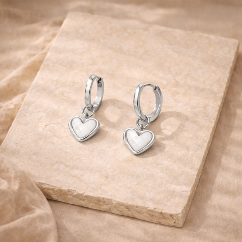 Silver FJØRNA White Quartz Heart Huggie Earrings for women, featuring heart-shaped white quartz stones and sleek hoop design.