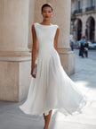 FJØRNA sleeveless pleated midi dress with draped neck, flowing fabric, and elegant design perfect for formal occasions.