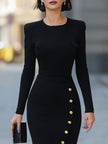 FJØRNA black long-sleeve fitted midi dress with gold button slit detail, showcasing a sleek, elegant design with a stylish slit.