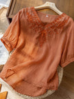 FJØRNA women's summer blouse with V-neck, linen fabric, flowy casual top, worn by a model in a bright outdoor setting