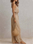 Tan cotton linen sleeveless jumpsuit with halter neck and smocked waist, wide-leg design by FJØRNA.