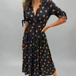 FJØRNA summer mini dress for women featuring a polka dot pattern and V-neck design, perfect for warm weather.