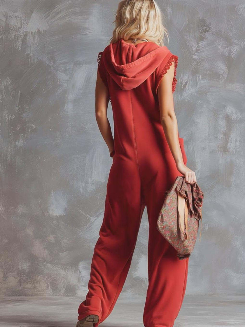 Raspberry red cotton hooded zip-front jumpsuit by FJØRNA, featuring a relaxed fit and front zipper detail.