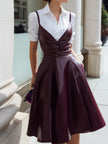 White button-up shirt dress by FJØRNA with wine-red leather suspender overlay, structured and stylish for a modern look.
