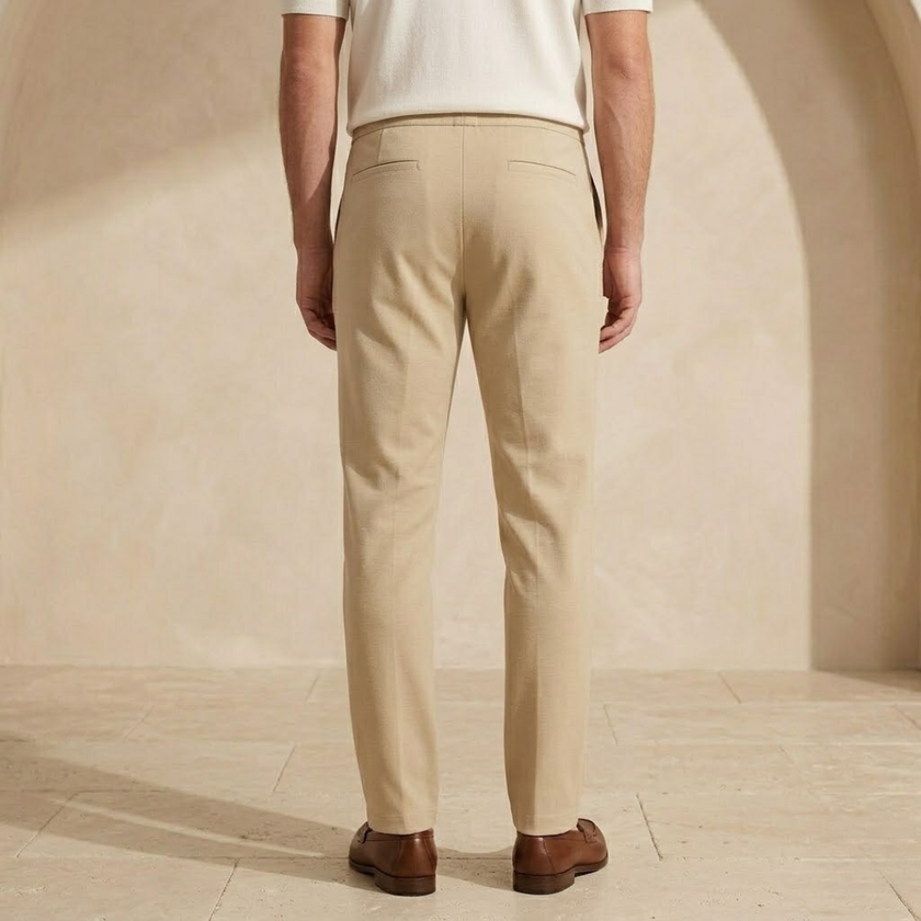 FJØRNA men's straight leg trousers with drawstring, relaxed fit, casual pants in neutral fabric, shown hanging or laid flat.
