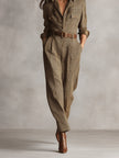FJØRNA women's plaid jumpsuit with tweed texture, collared V-neck, utility pockets, and tailored pants style.