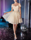 FJØRNA champagne tulle cocktail dress for women with off-shoulder design and elegant ruffle details.