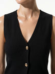 Close-up of FJØRNA women's sleeveless structured waistcoat, tailored layering piece with a fitted, professional look.