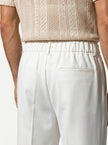 Close-up of FJØRNA men's straight fit tailored trousers showing the fabric texture and classic design details.