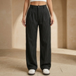 Women’s high-waisted pinstripe wide-leg trousers by FJØRNA shown on a model, featuring a tailored fit and classic pattern.
