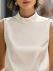 Ivory satin sleeveless blouse for women with high neck, stylish FJØRNA top, elegant and smooth fabric detail visible.