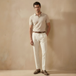 FJØRNA men's linen blend straight leg trousers with relaxed fit, showing light beige fabric and tailored waistband.