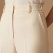 FJØRNA women's relaxed fit straight leg trousers, stylish pants in a neutral color, shown on a model.