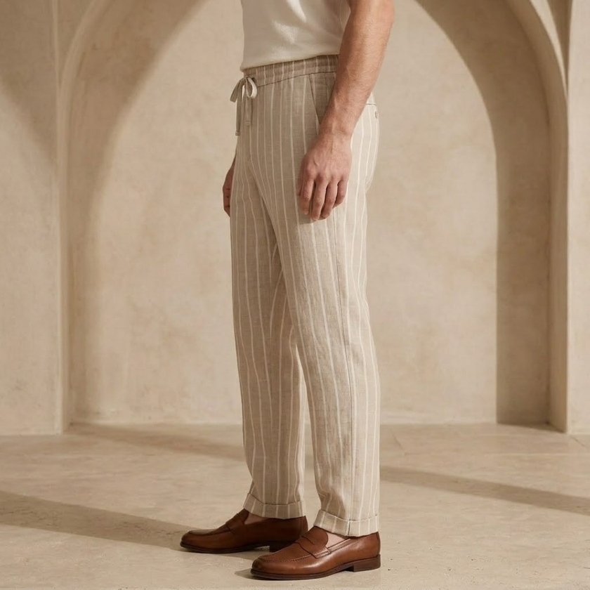 FJØRNA men's linen trousers with drawstring waist, relaxed fit, lightweight breathable fabric, shown on a model.