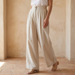 FJØRNA women's linen wide-leg trousers featuring high waist and tailored fit, shown on model with front view.