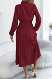 FJØRNA solid color long-sleeved fitted waist pleated midi dress shown on a model, elegant and stylish for formal occasions.