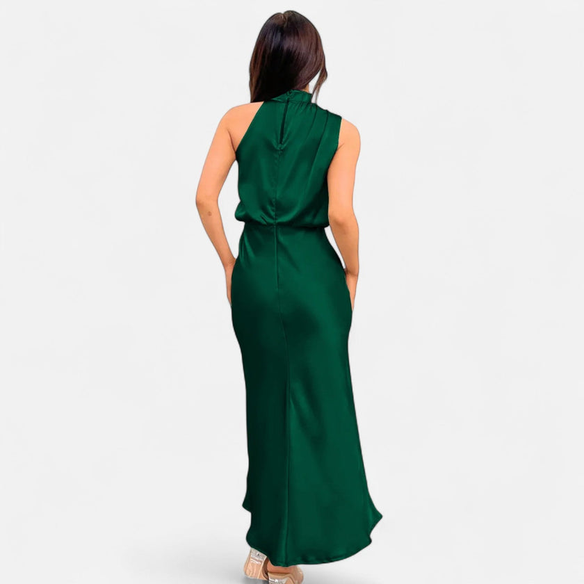 FJØRNA draped sleeveless halter maxi dress displayed on a model, featuring flowing fabric and elegant design for formal occasions.