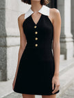 Black sleeveless halter mini dress with white collar detail by FJØRNA, showing the dress's fitted silhouette and stylish collar design.