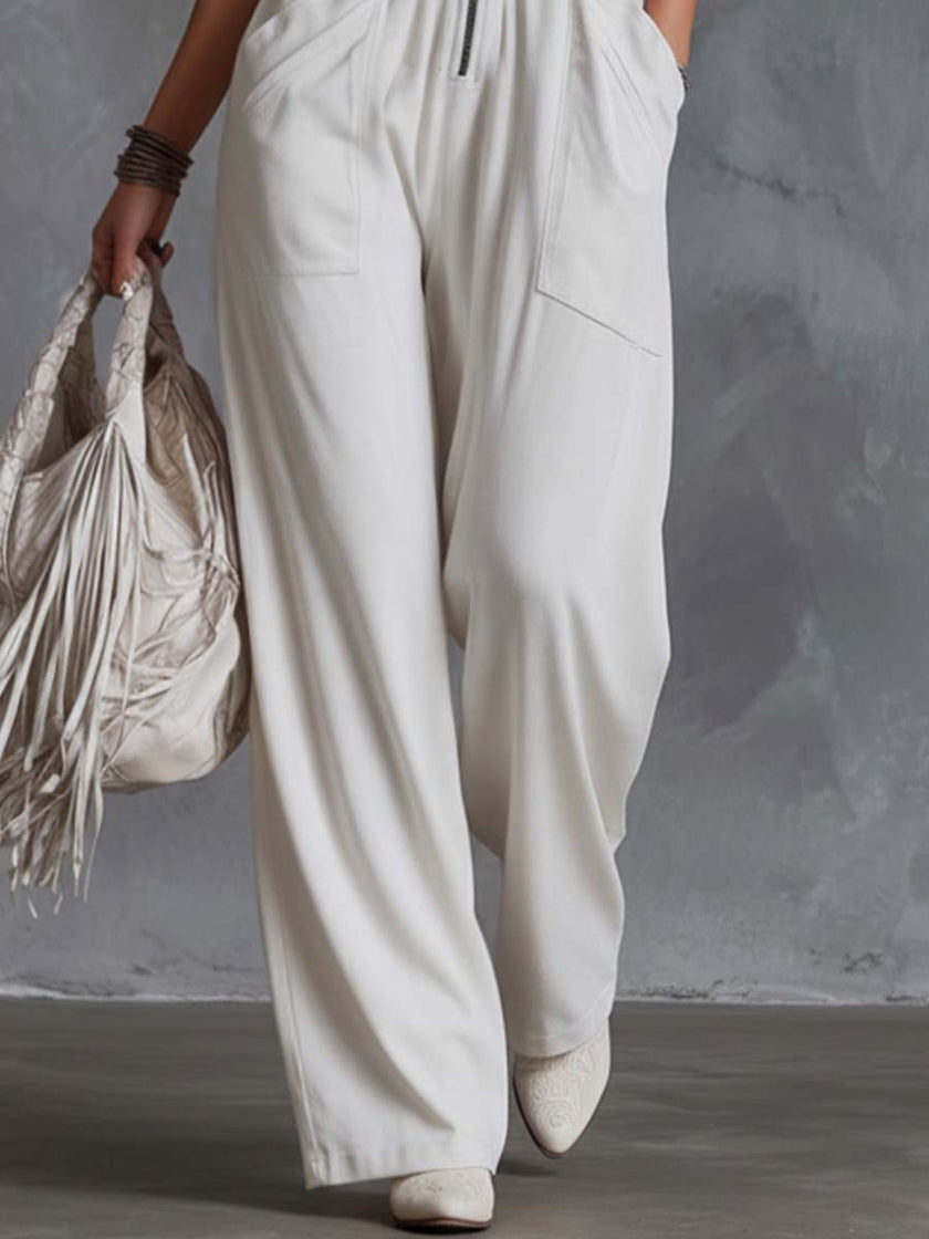 White faux suede western fringe V-neck jumpsuit by FJØRNA with fringe details and a stylish V-neck design.