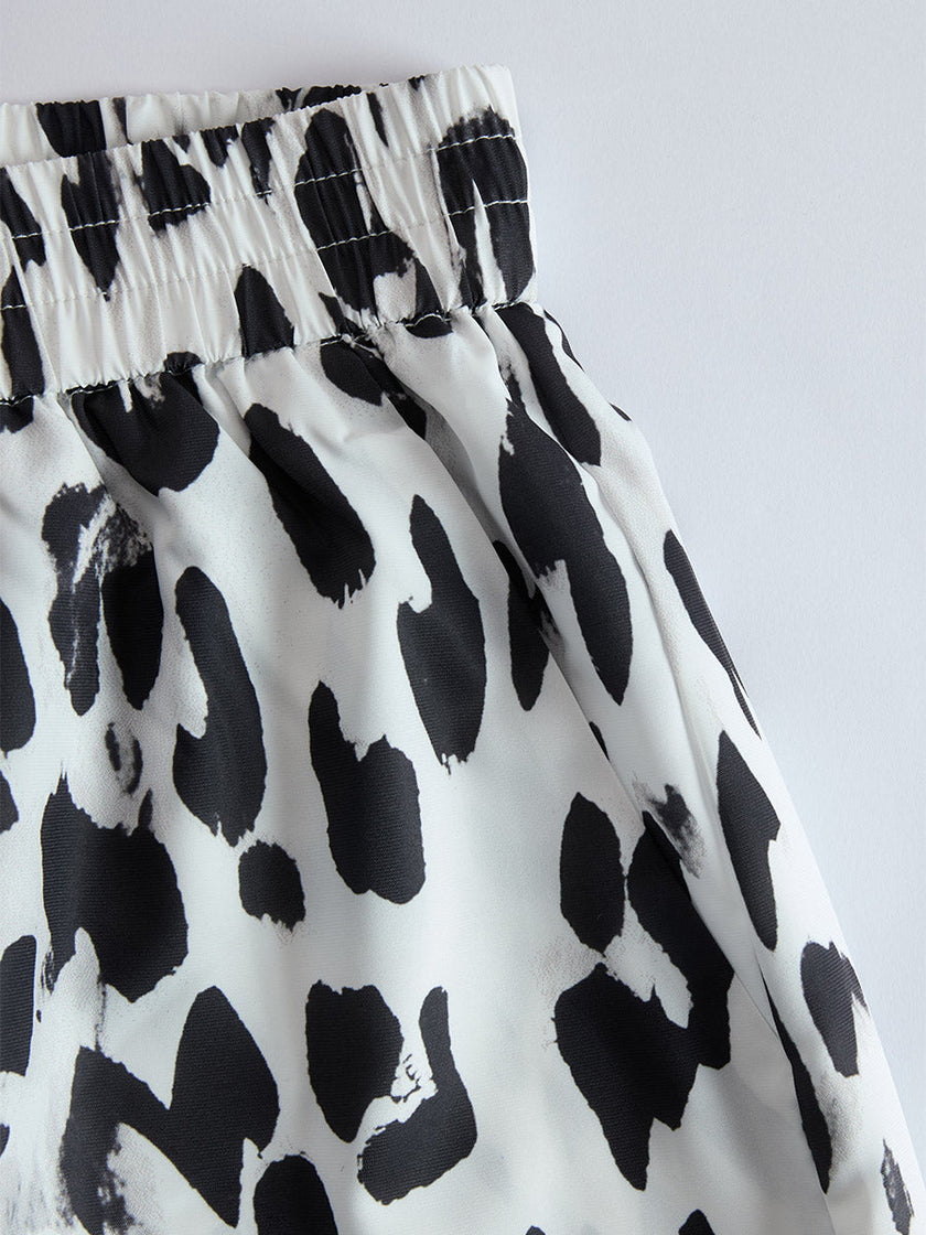 White leopard print chiffon wide-leg trousers for women by FJØRNA, featuring flowing fabric and relaxed fit.