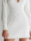 FJØRNA white long-sleeve mini dress with pearl-embellished keyhole neckline, stylish and elegant for evening wear.