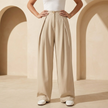 Women’s high waisted wide leg tailored trousers by FJØRNA, featuring a sleek fit and crisp fabric in a neutral color.