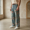 Men's denim jeans by FJØRNA featuring floral embroidery, classic fit, and casual style, shown on a model.